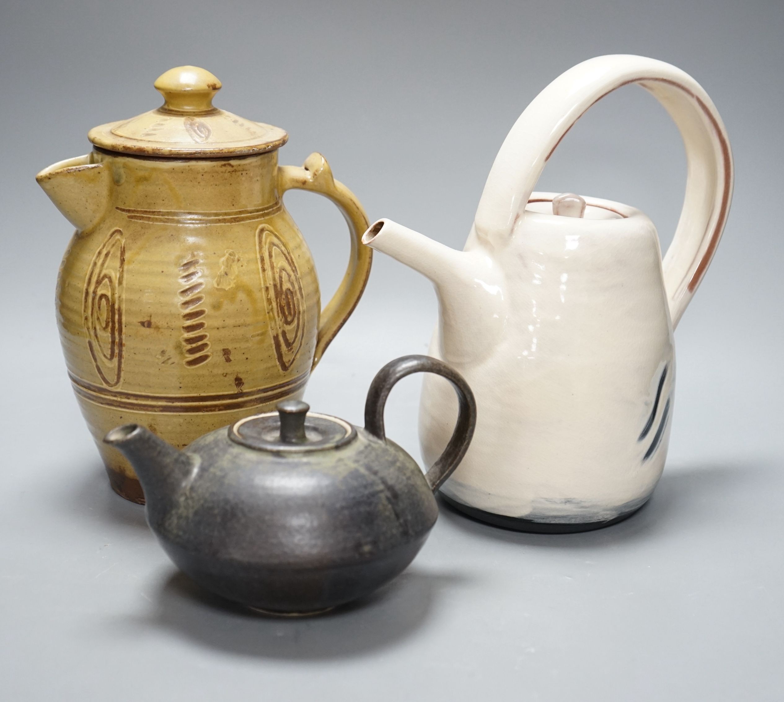 British studio pottery; a Jane Sawyer coffee pot and cover, Danlami Aliyu, for Wenford Bridge Pottery, pale green glazed stone were covered jug, and a black glazed white stoneware teapot, tallest 25cm, (3)